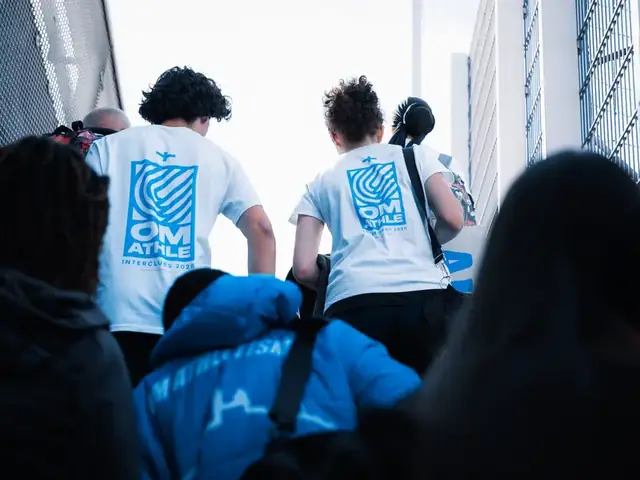 Athlètes de l'OM Athlétisme en t-shirt Interclubs montant vers la piste