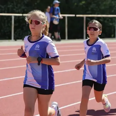 Deux jeunes filles de l'école d'athlétisme de l'OM en course sur la piste